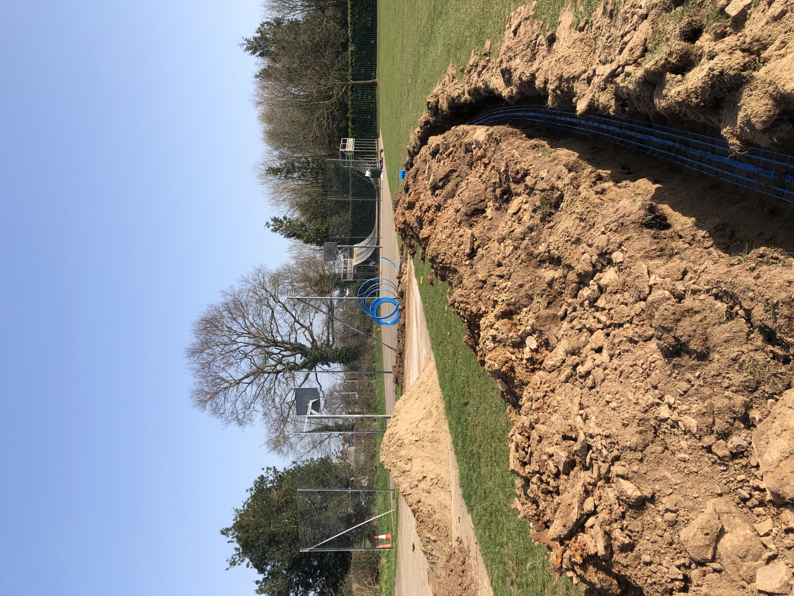 Installation of the new irrigation system at the cricket pitch at The Park. A long narrow trench cut in the turf.