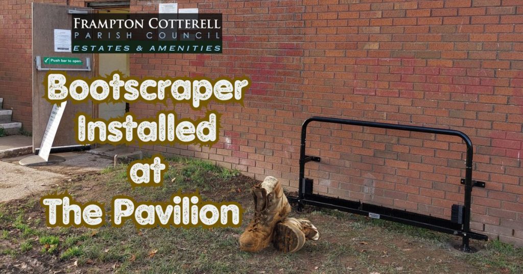Photograph of a black metal boot scraper against the brick wall of the Pavilion at the Park, School Road, in Frampton Cotterell. Text to the left reads, Frampton Cotterell Parish Council Estates & Amenities: Boot Scraper Installed at The Pavilion.